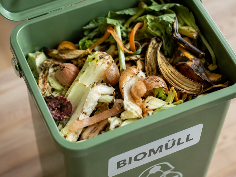 Biomüll-Behälter gefüllt mit Gemüseresten und Bananenschalen